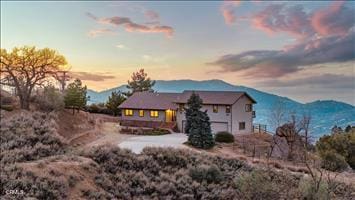 back house at dusk featuring a mountain view