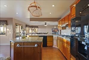 kitchen with ceiling fan, stainless steel gas cooktop, kitchen peninsula, light hardwood / wood-style floors, and a kitchen island