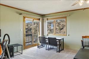 dining space featuring ceiling fan, light colored carpet, and ornamental molding