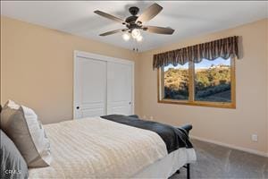 carpeted bedroom with a closet and ceiling fan