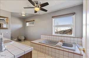 bathroom featuring ceiling fan and tile patterned flooring