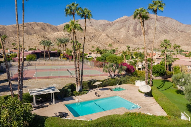 view of swimming pool featuring a mountain view, tennis court, and a pergola