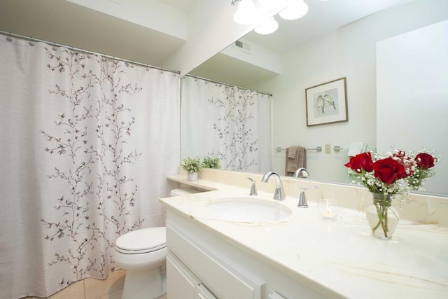 bathroom with tile patterned flooring, vanity, and toilet