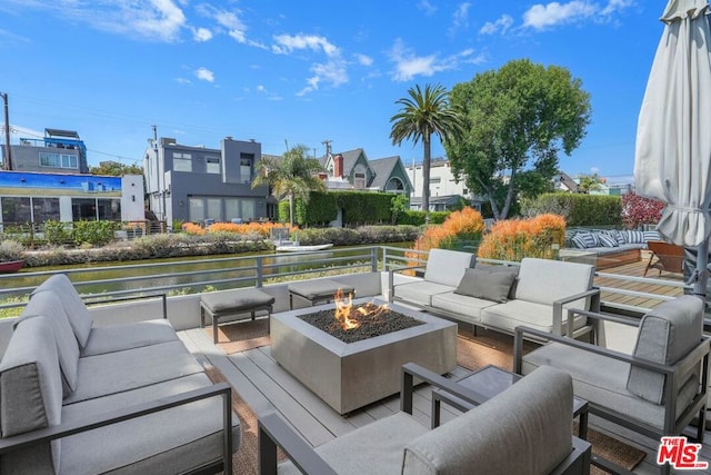 view of patio / terrace with a water view and an outdoor living space with a fire pit