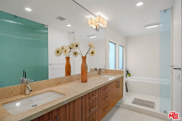 bathroom featuring vanity, a relaxing tiled tub, and tile patterned floors