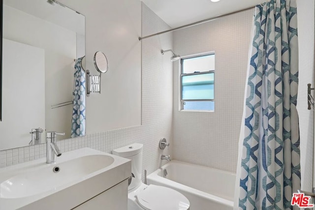 full bathroom featuring vanity, shower / bathtub combination with curtain, tile walls, and toilet