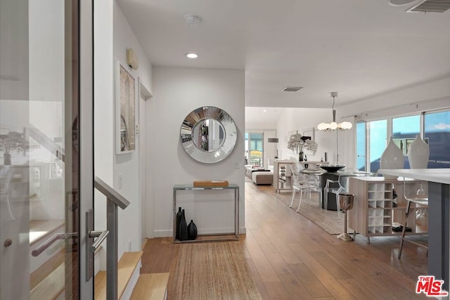 entryway featuring hardwood / wood-style floors, a healthy amount of sunlight, and an inviting chandelier