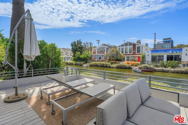 wooden deck featuring an outdoor living space and a water view