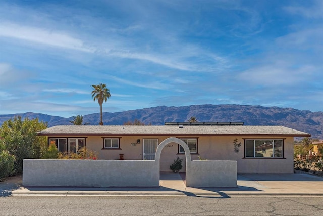 ranch-style house with solar panels and a mountain view