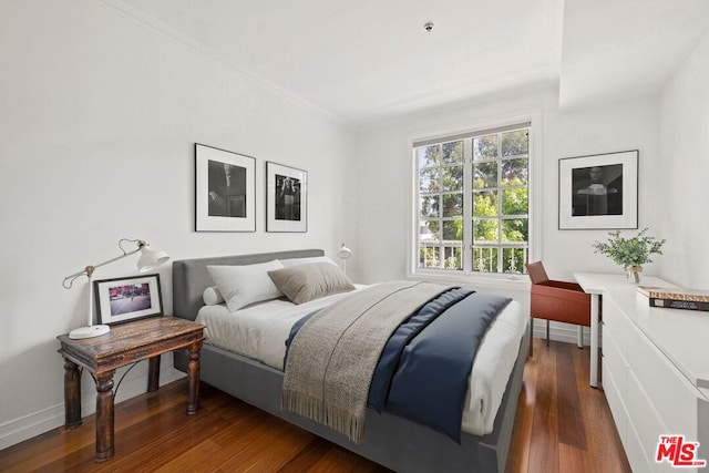 bedroom featuring ornamental molding and dark wood-type flooring