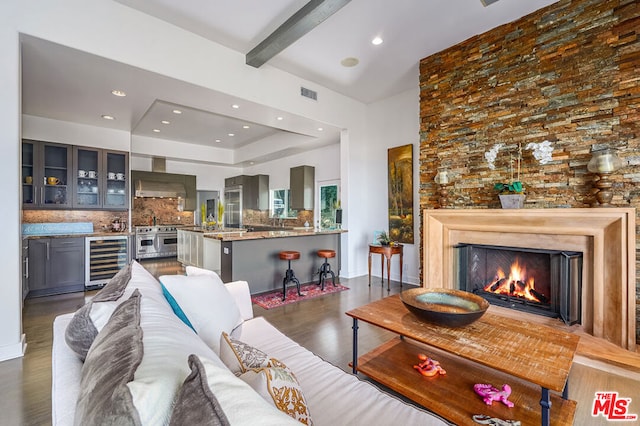 living room featuring beamed ceiling, beverage cooler, and dark hardwood / wood-style floors