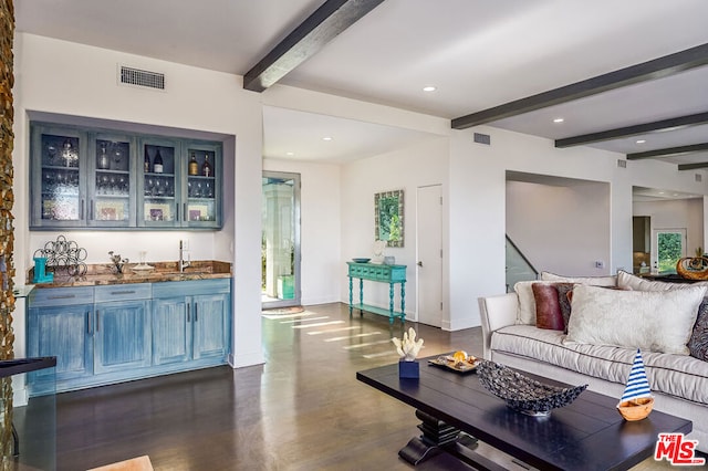 living room with beamed ceiling, dark hardwood / wood-style flooring, and wet bar