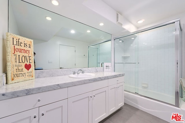 bathroom featuring shower / bath combination with glass door and vanity