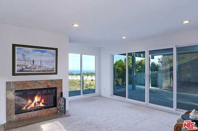 unfurnished living room with a fireplace and carpet