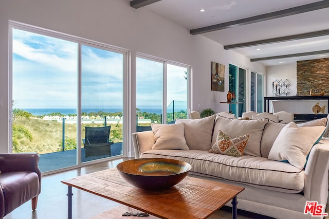 living room featuring beam ceiling, a water view, and concrete floors