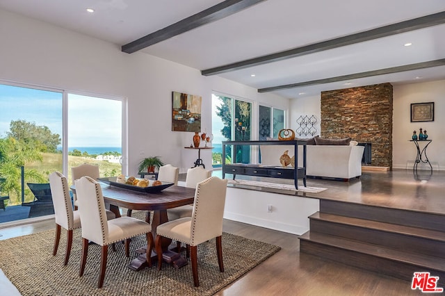 dining room with beamed ceiling, wood-type flooring, and a fireplace