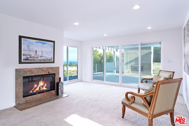 sitting room with a fireplace and carpet floors