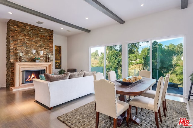 dining room with a fireplace, beamed ceiling, and hardwood / wood-style floors