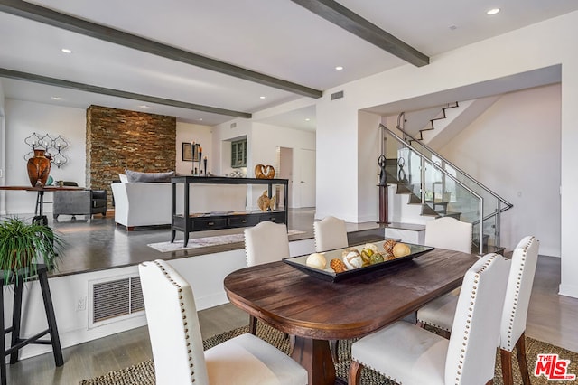 dining area with beamed ceiling and dark wood-type flooring