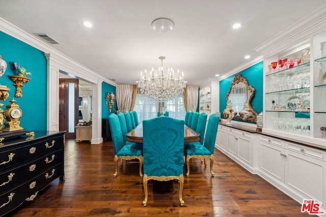 dining room featuring dark hardwood / wood-style flooring, crown molding, and a notable chandelier