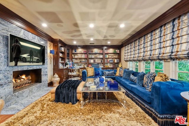 sitting room with a fireplace, built in features, and crown molding