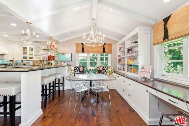 kitchen with pendant lighting, a breakfast bar, dark wood-type flooring, white cabinets, and vaulted ceiling with beams