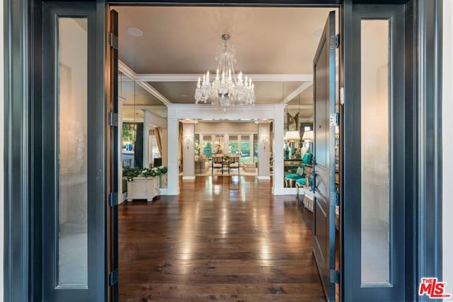 corridor featuring crown molding, dark wood-type flooring, and a chandelier