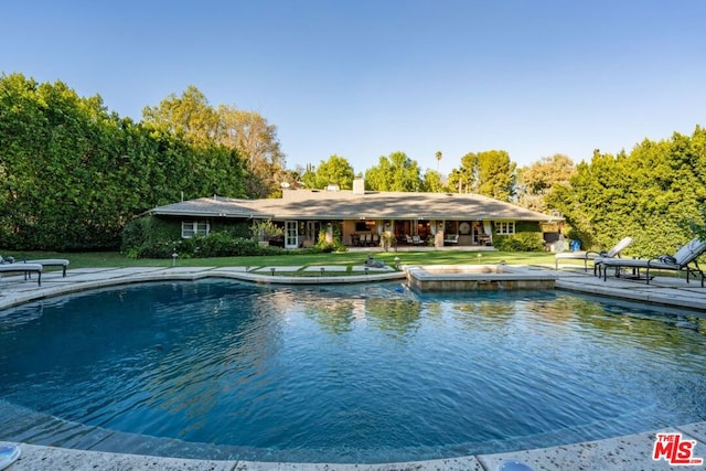 view of pool with a yard, a water view, and a patio