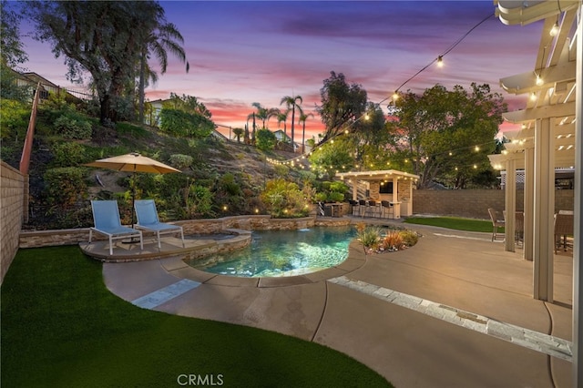 pool at dusk featuring a patio and an outdoor bar