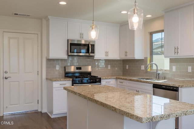 kitchen featuring sink, white cabinetry, tasteful backsplash, a kitchen island, and stainless steel appliances