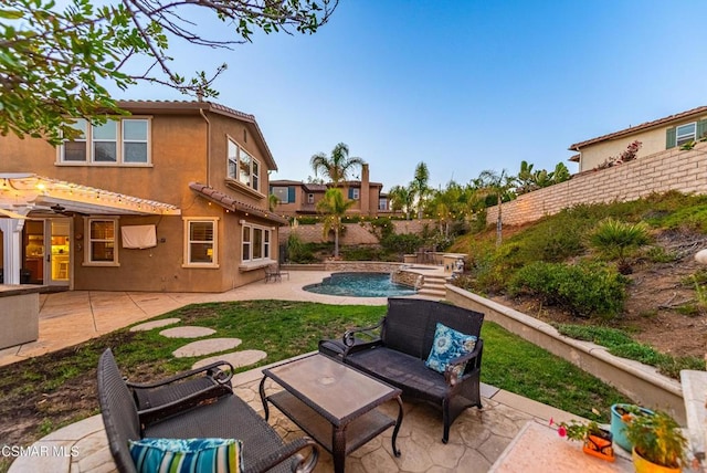 back of property featuring a fenced in pool, a patio area, and an outdoor living space