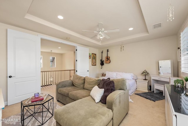 carpeted living room featuring a tray ceiling and ceiling fan