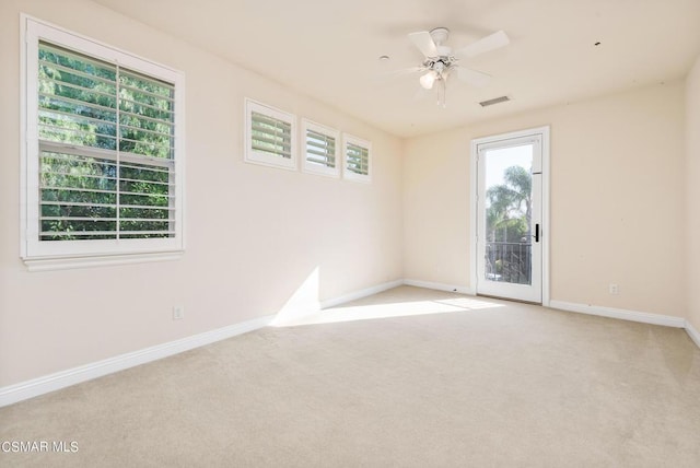 empty room featuring ceiling fan and light colored carpet