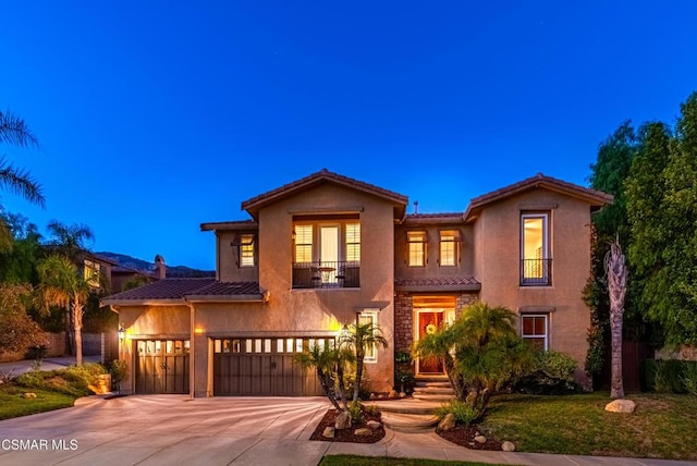 mediterranean / spanish house featuring a balcony and a garage