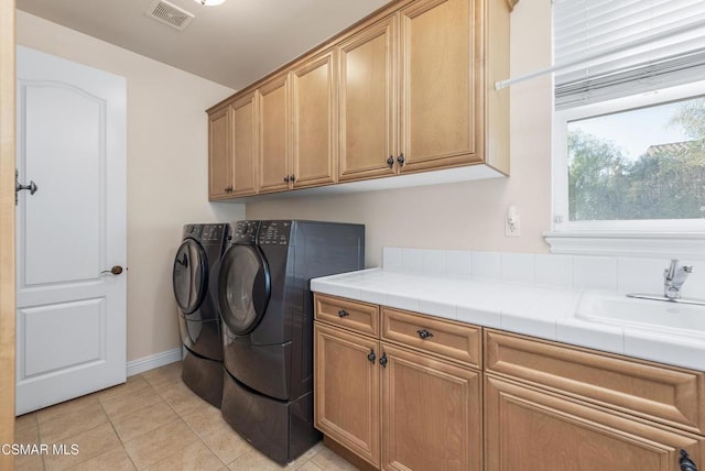 laundry room with cabinets, separate washer and dryer, sink, and light tile patterned floors