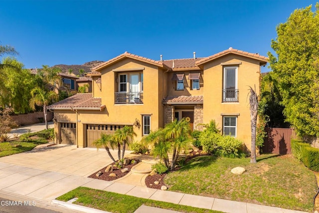 mediterranean / spanish house featuring a garage, a balcony, and a front lawn