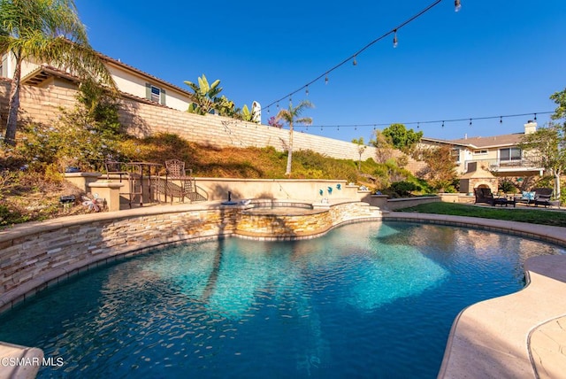 view of pool featuring an in ground hot tub, a patio, exterior bar, and an outdoor fireplace