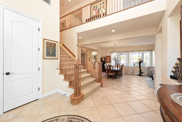 tiled foyer entrance featuring an inviting chandelier