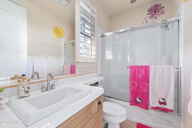 full bathroom with vanity, enclosed tub / shower combo, and toilet