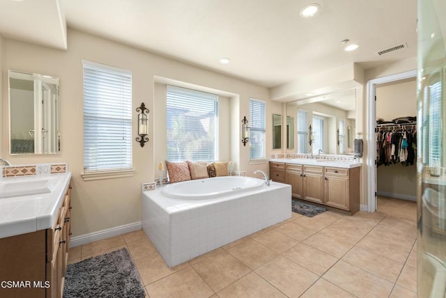 bathroom with vanity, tiled bath, and tile patterned floors