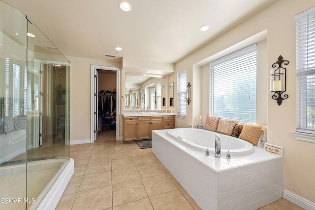 bathroom with tile patterned flooring, vanity, and plus walk in shower