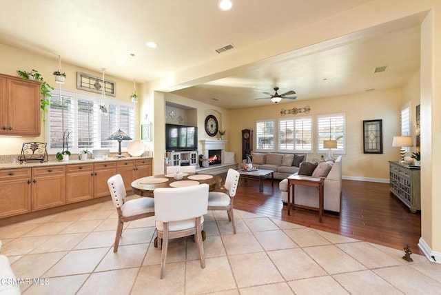 dining space with ceiling fan and light hardwood / wood-style flooring