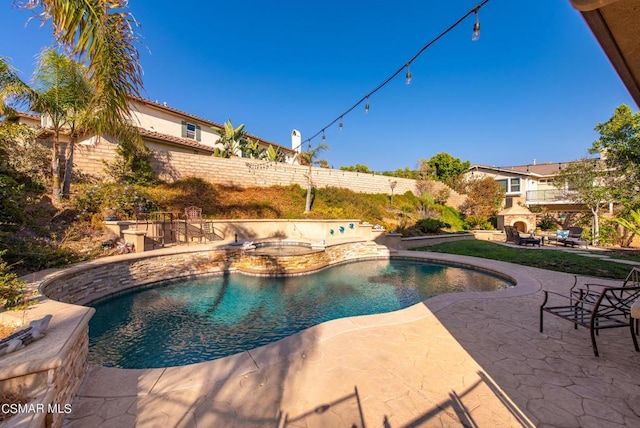 view of swimming pool with a multi sided fireplace, a patio area, and an in ground hot tub