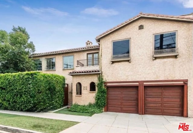 mediterranean / spanish home featuring a balcony and a garage