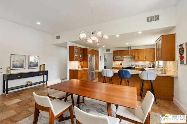 dining space with an inviting chandelier and sink