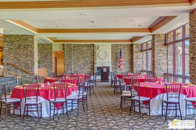 dining space with carpet floors, crown molding, and a raised ceiling