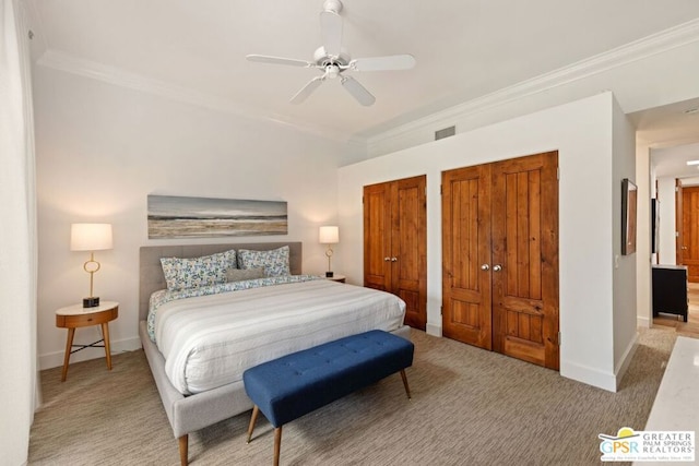 bedroom featuring ceiling fan, two closets, crown molding, and light colored carpet