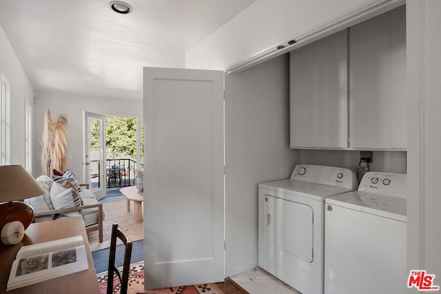 laundry room featuring washer and dryer and cabinets