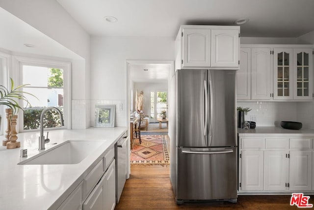 kitchen featuring white cabinetry, sink, dark wood-type flooring, decorative backsplash, and appliances with stainless steel finishes