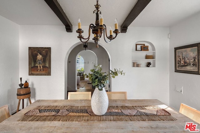 room details with built in shelves, beamed ceiling, and an inviting chandelier